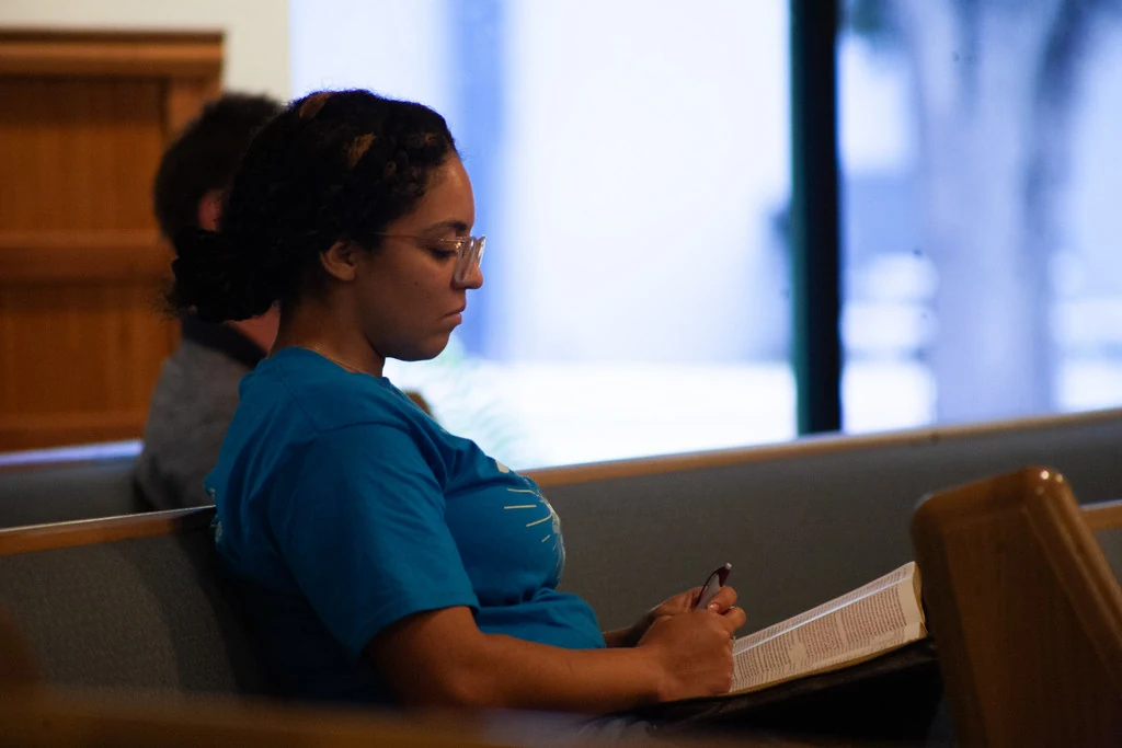A woman at The Way following along with an open Bible
