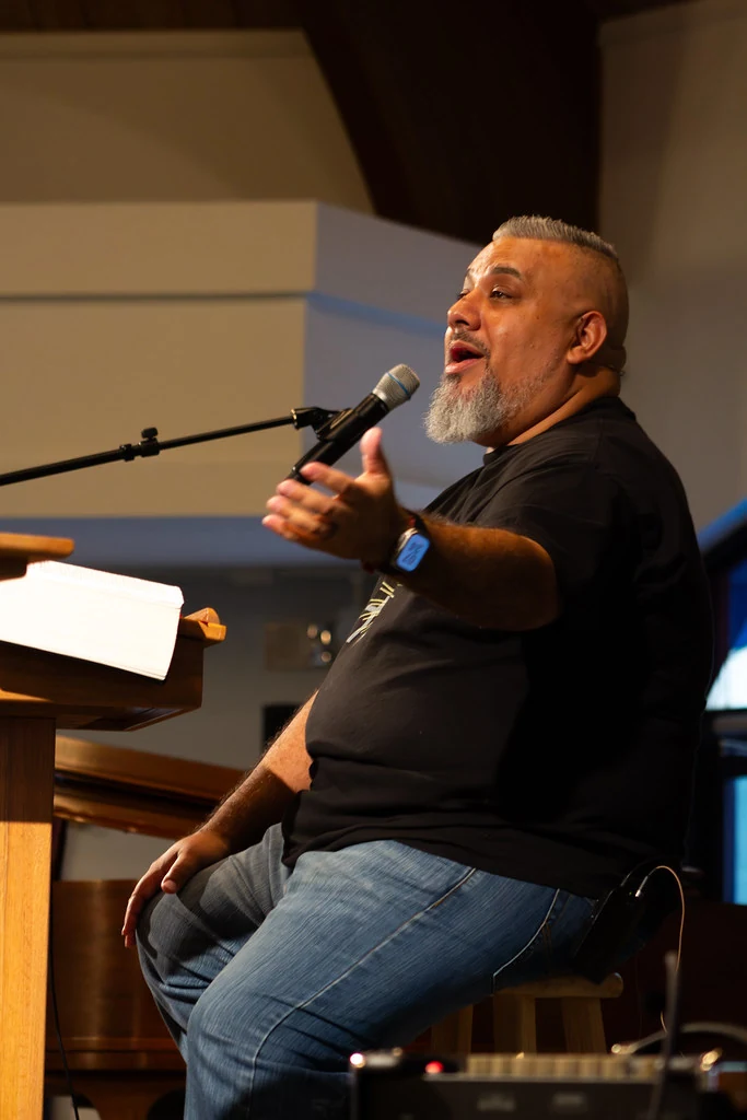 Pastor Damien teaching with an open Bible at The Way